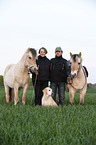 Mann und Frau mit Pferden und Hund