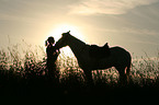 junge Frau mit Pferd im Sonnenuntergang