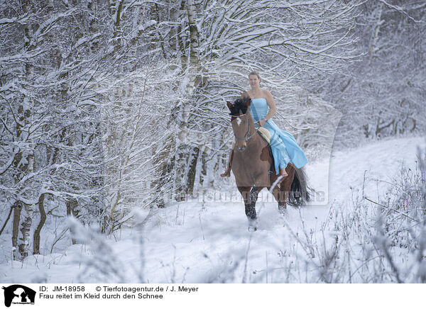 Frau reitet im Kleid durch den Schnee / JM-18958