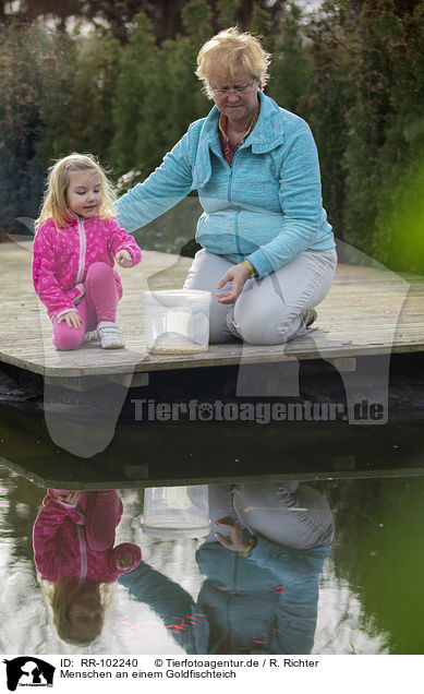 Menschen an einem Goldfischteich / RR-102240