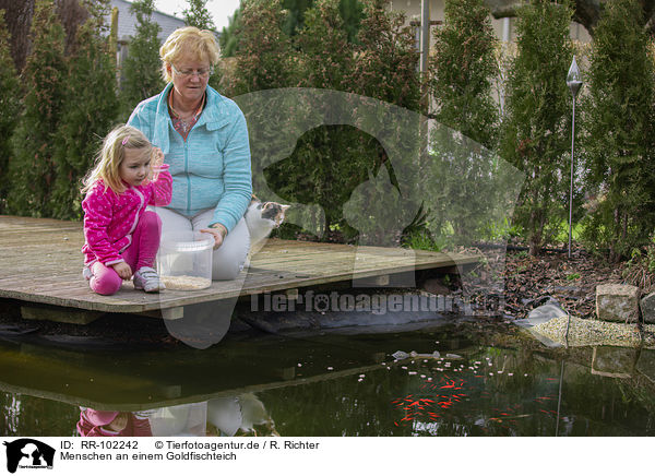 Menschen an einem Goldfischteich / RR-102242