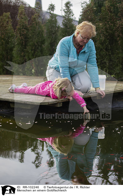 Menschen an einem Goldfischteich / RR-102246