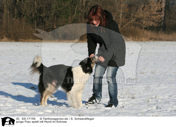 junge Frau spielt mit Hund im Schnee / playing with dog in the snow / SS-17159
