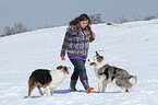 Frau mit 2 Hunden im Schnee