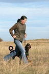 Frau rennt mit Dobermann