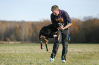 Mann spielt mit Groem Schweizer Sennenhund