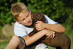 Junge und Labrador Retriever Welpe