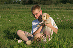 Junge und Labrador Retriever Welpe