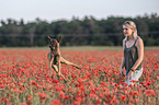 Frau mit Malinois im Mohnfeld