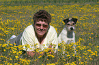 Frau mit Parson Russell Terrier auf Blumenwiese
