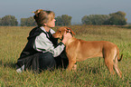 Frau kuschelt mit Rhodesian Ridgeback