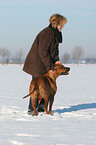 Frau mit Rhodesian Ridgeback im Schnee