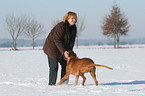 Frau mit Rhodesian Ridgeback im Schnee
