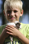 Junge mit Rosettenmeerschwein
