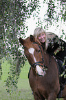 Frau reitet Deutsches Reitpony