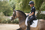 Mdchen reitet Deutsches Reitpony