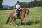 junge Frau reitet Deutsches Reitpony