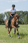 junge Frau reitet Deutsches Reitpony