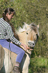 Frau reitet Fjordpferd