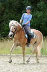 Frau reitet Haflinger