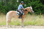 Frau reitet Haflinger