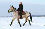 Frau reitet Appaloosa-Mix