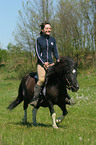 Frau reitet Shetland Pony