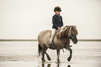 Mdchen reitet Shetland Pony
