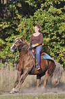Frau reitet Pferd