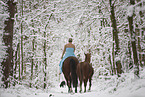 Frau reitet im Kleid durch den Schnee