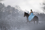 Frau reitet im Kleid durch den Schnee