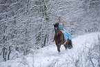 Frau reitet im Kleid durch den Schnee