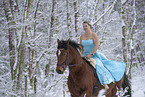 Frau reitet im Kleid durch den Schnee