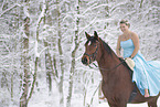 Frau reitet im Kleid durch den Schnee