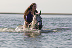 Frau und Lipizzaner-Mix im Wasser