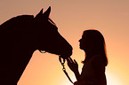 Frau mit Pferd im Sonnenuntergang