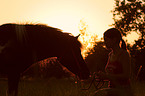 Frau mit Shetland Pony im Abendlicht